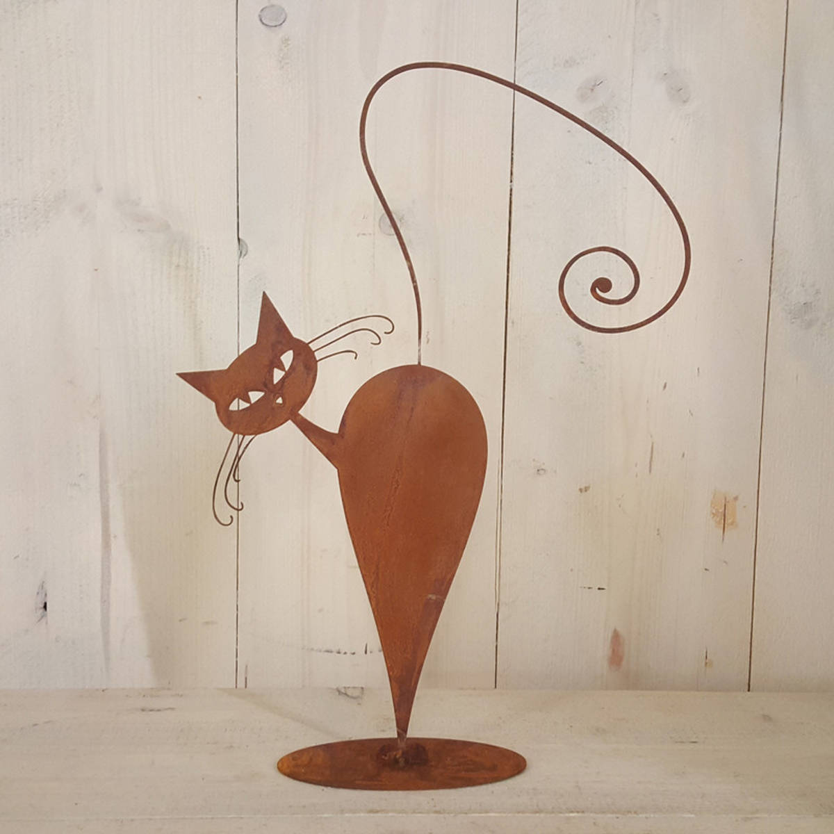 Katze aus Rosteisen auf einer Platte
