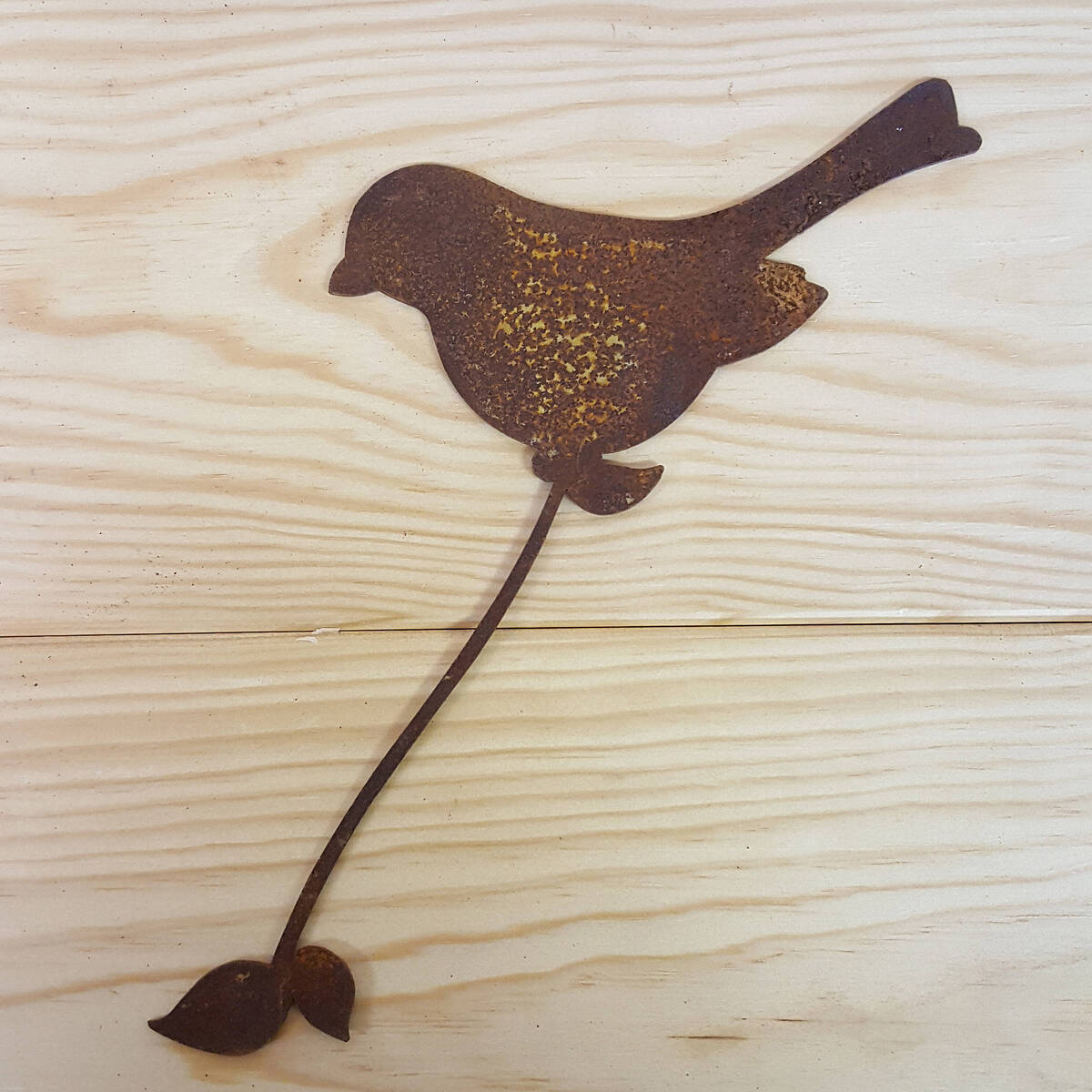 Vogel aus Rostmetall, um ein Objekt zu umwickeln