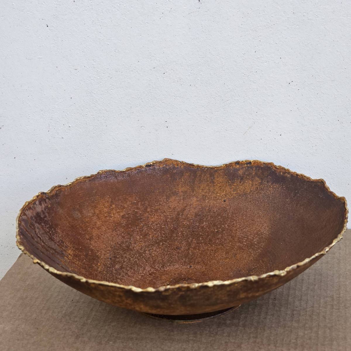 Coupe en fer rouillé, bordure or, D. 34 cm 